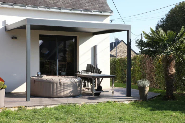 pergola prix usine baie des tortues recouvrant un spa gonflable sur une terrasse ensoleillée devant une maison contemporaine 