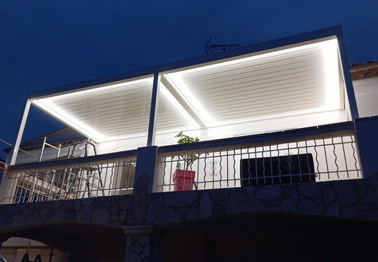 pergola bioclimatique éclairée par des LED blanches sur un balcon la nuit