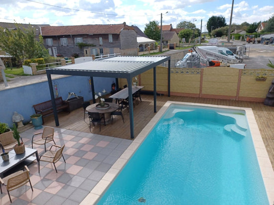 pergola bioclimatique autoportée au bord d'une piscine 