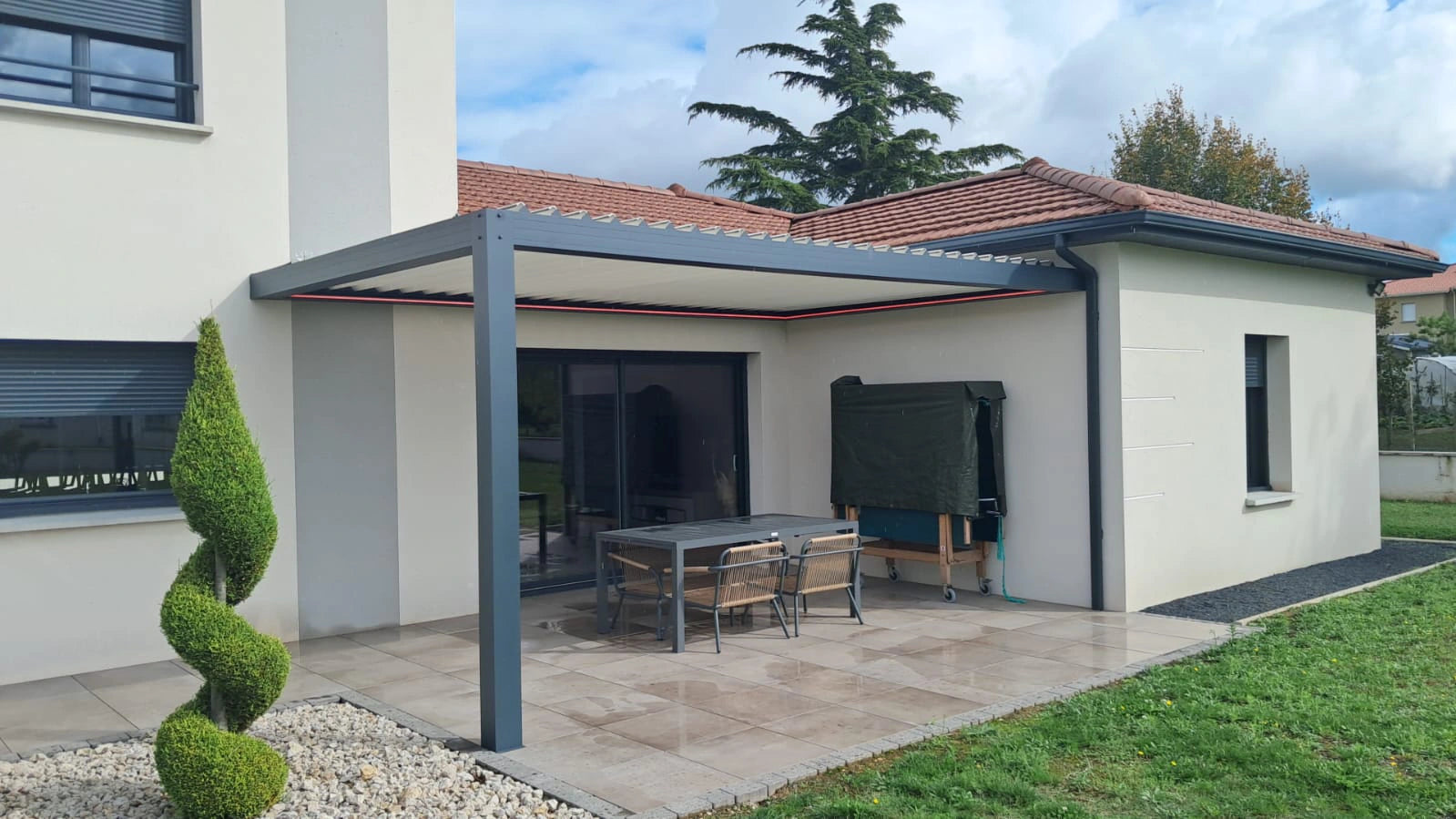 pergola bioclimatique aluminium sur mesure posée en angle sur maison contemporaine avec jardin moderne