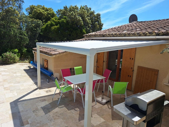 pergola toile adossée sur maison tuiles en plein été terrasse piscine